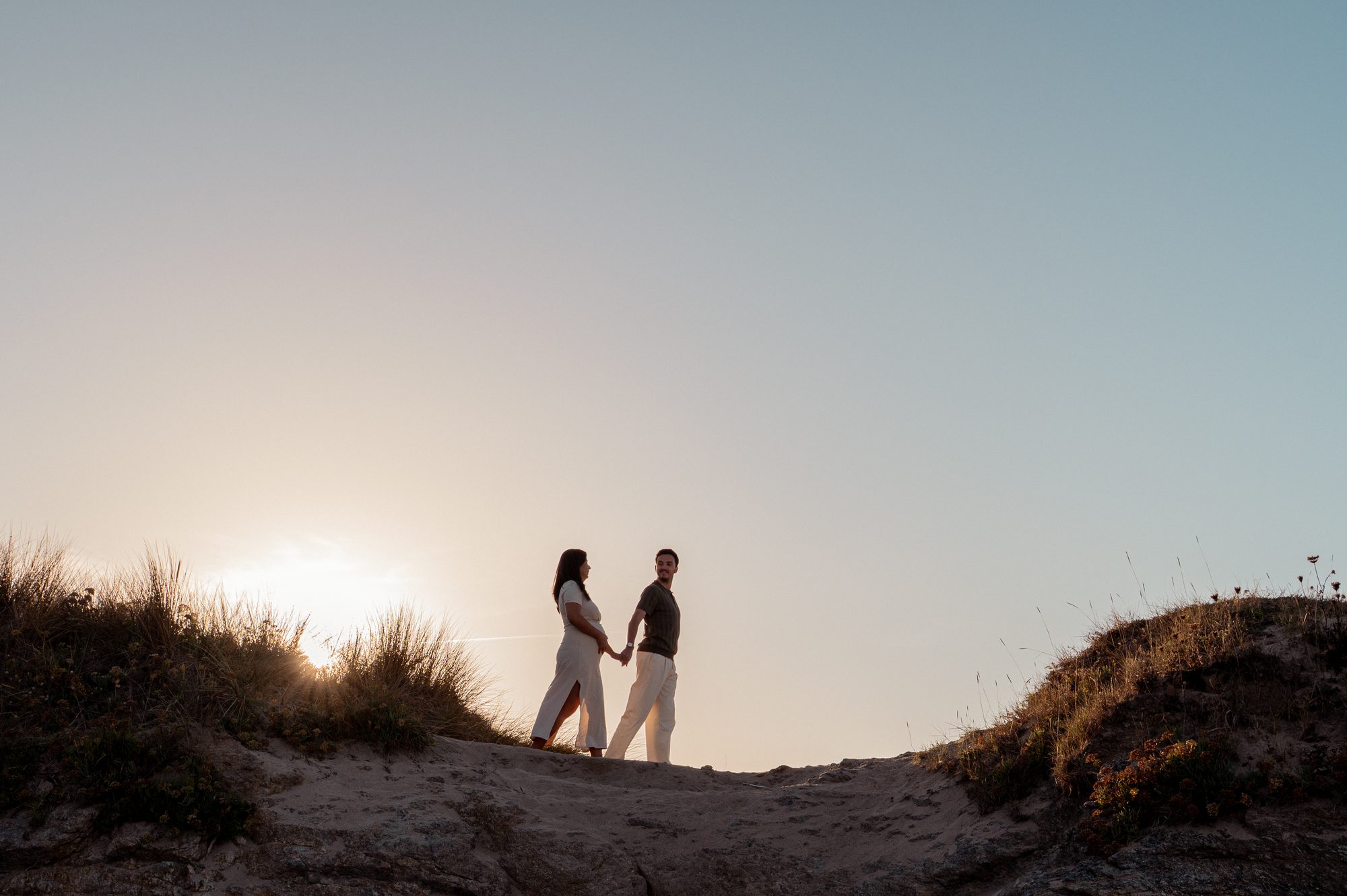 Abi et Flo main dans la main sur une dune, au coucher du soleil
